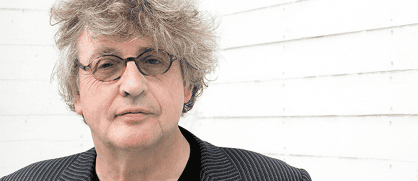 A person with curly hair wearing glasses
Description automatically generated